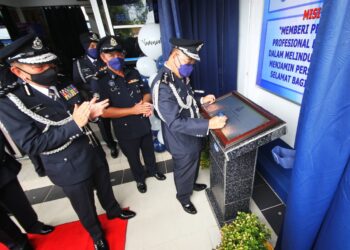 SHAFIEN Mamat menandatangani plak sebagai gimik perasmian Balai Polis Palekbang, Tumpat, Kelantan, hari ini. - UTUSAN/ZULHANIFA SIDEK