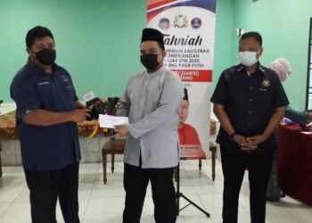 MAZLAN Bujang (kiri) menyampaikan sumbangan kepada pelajar cemerlang SPM 2020 dalam program Penyampaian Anugerah Kecemerlangan Pelajar SPM 2020 di Kampung Pasir Putih, Pasir Gudang, Johor.