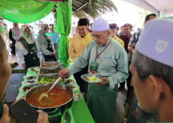 AHMAD Yakob mengambil hidangan  ketika melawat gerai-gerai dalam Majlis Rumah Terbuka Aidilfitri Pas Kelantan di Stadium Sultan Muhammad IV, Kota Bharu, Kelantan hari ini. UTUSAN/MUSTAQIM MOHAMED