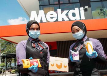 Kakitangan McDonald’s, Putri Fatin Fatiqah Roslee (kanan) dan Shahrul Syalili Mat Sharif menunjukkan hidangan terbaharu Mekdi 
di Putrajaya, semalam.