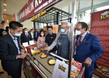 MENTERI Pembangunan Usahawan dan Koperasi, Tan Sri Noh Omar cuba memasak apam balik dalam satu program pembangunan
usahawan anjuran kementerian, baru-baru ini.