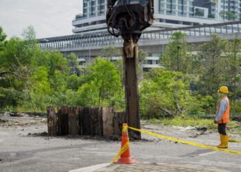 KONTRAKTOR giat melakukan kerja-kerja pemasagan cerucuk bagi menahan pergerakan tanah dalam kejadian tanah mendap dan runtuhan berhampiran longkang pada petang semalam di deretan kedai Jalan LP 1A/2 Lestari Perdana di sini, hari ini. -UTUSAN/ FARIZ RUSADIO