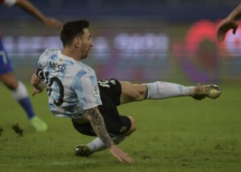 LIONEl Messi terjatuh ketika cuba melakukan tendangan dalam aksi Copa America menentang Chile di Stadium Nilton Santos, Rio de Janeiro hari ini. - AFP
