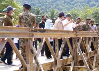 ISMAIL SABRI Yaakob diberi penerangan mengenai pembinaan jambatan Compact Bailey 100 di Kampung Sungai Putat, Jerantut, Pahang. – UTUSAN/HARIS FADILAH AHMAD