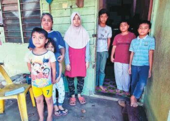 HAJIAH Hairun (tiga dari kiri) bersama enam beradik yatim piatu yang tinggal di Kampung Pekan Tangga Batu, Melaka. – FOTO/AMRAN MULUP