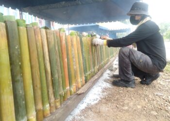 SEORANG pekerja Gerai Lemang Kak Ngah Cheng membakar lemang untuk dijual kepada pelanggan di Cheng, Melaka. - UTUSAN/MUHAMMAD SHAHIZAM TAZALI