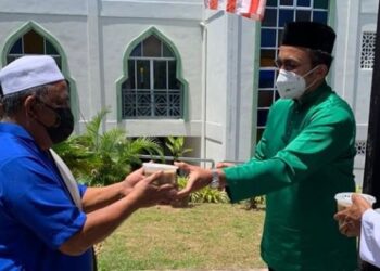 MOHD. Rafiq Naizamohideen (kanan) mengagihkan bubur lambuk kepada para jemaah di Masjid Ibadur Rahman, Tangga Batu Kechil, Melaka.
