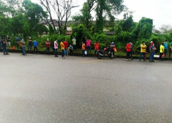 PEKERJA warga asing sedang beratur menunggu bas untuk dipindahkan ke pangsapuri di Taman Bunga Raya, Bukit Beruang, Melaka. - UTUSAN/AMRAN MULUP