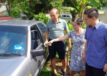 GUE Boon Guan (kiri) dan Gan Chui Lan (tengah) menunjukkan kepada Lim Ban Hong keadaan cermin kereta mereka yang dipecahkan dua penyamun dalam kejadian di Taman Megah, Klebang, Melaka. - UTUSAN/AMRAN MULUP