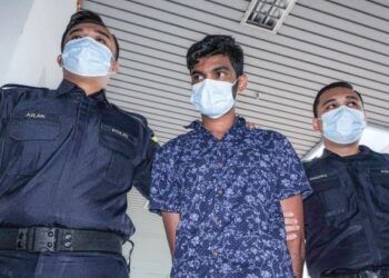 TERTUDUH diiring keluar anggota polis selepas dihadapkan ke Mahkamah Majistret, Ayer Keroh, Melaka atas pertuduhan menyebabkan kematian Sa’adon Sahat pada Februari lalu. – UTUSAN/SYAFEEQ AHMAD