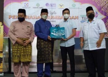 GHAZALI Omar (dua dari kiri) menyampaikan sumbangan berupa pek makanan asas kepada seorang pelajar pada majlis penyerahan sumbangan YaPEIM sempena Pesta Konvo Maya Tuah di Kampus Induk UTeM di Durian Tunggal, Melaka.