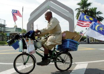 SUHAIMI Bulat berbasikal dari Bukit Palah ke Bukit Baru, Melaka untuk membeli Jalur Gemilang menggunakan pendapatan hariannya sebagai pengutip barangan terpakai. - UTUSAN/RASUL AZLI SAMAD