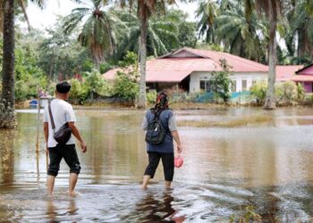 Walaupun kawasan rumah masih digenangi air, mangsa banjir di Pusat Pemindahan Sementara (PPS) Sekolah Kebangsaan Seri Mendapat mulai pulang ke rumah masing-masing untuk membersihkan rumah mereka pada hari kesembilan di Kampung Lanchang, Merlimau, Jasin. – UTUSAN/RASUL AZLI SAMAD