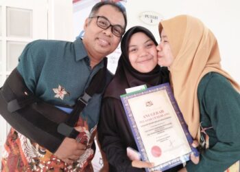 NUR ZAWANI Mardhiah Zainal (tengah) diapit bapa, Zainal Zakaria dan ibunya, Munirati Ibrahim pada Majlis Apresiasi Pelajar Cemerlang STPM dan Hafiz di Ayer Keroh, Melaka. - UTUSAN/MUHAMMAD SHAHIZAM TAZALI