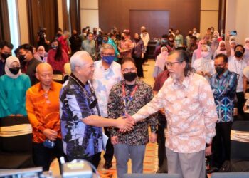 MENTERI Komunikasi dan Multimedia, Tan Sri Annuar Musa bersalam dengan Ahmad Murad Merican dalam Forum Media Nasional sempena Hari Wartawan Nasional 2022 di Melaka, baru-baru ini. – UTUSAN/RASUL AZLI SAMAD