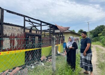 ROBIAH Saidin dan Muhammad Shahrul Noordin melihat rumah mereka yang terbakar dalam kejadian di Lorong Haji Manaf, Tangga Batu, Melaka.