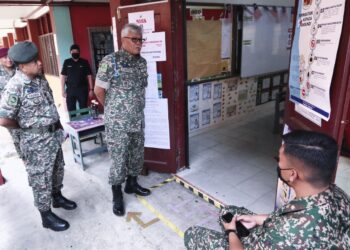 Panglima Tentera Darat, Jeneral Tan Sri Zamrose Mohd. Zain (dua dari kiri) melawat proses pengundian awal Angkatan Tentera Malaysia (ATM) di Sekolah Kebangsaan Kem Terendak 2, Melaka, semalam. - UTUSAN/ RASUL AZLI SAMAD