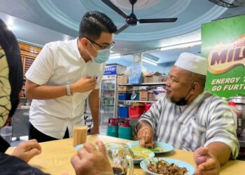 MUHAMAD Danish Zainudin (kiri) menyantuni masyarakat yang bersarapan di sebuah restoran di Peringgit, Melaka.
