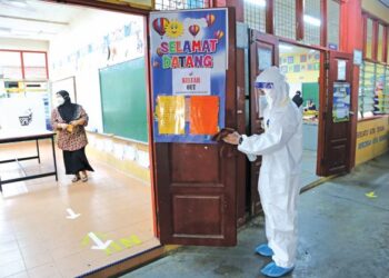 Petugas pembersihan melakukan kerja-kerja sanitasi semasa pengundian berlangsung di Sekolah Kebangsaan Jeram, Masjid Tanah pada Pilihan Raya Negeri Melaka (PRN), semalam. – MINGGUAN/AMIR KHALID