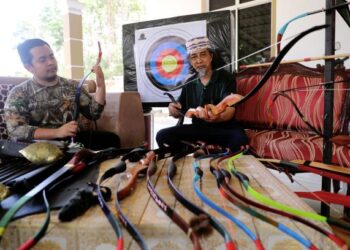 Sufyan (kanan) dan Fadhil menunjukkan antara jenis-jenis busur tradisional yang dihasilkan mereka berdua untuk Panah Taming Sari.