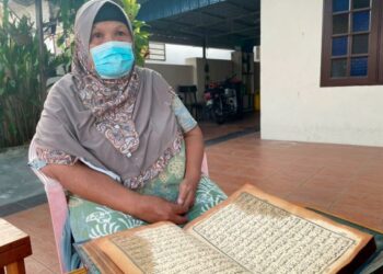 HABIBAH Md. Sab menunjukkan naskhah al-Quran yang tidak terbakar dalam kejadian kebakaran di Taman Kenanga 3, Klebang Besar, Melaka. – UTUSAN/DIYANATUL ATIQAH ZAKARYA