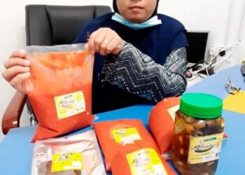 NORRABIATUL Adawiyah Abdul Karim menunjukkan Cili Boh Nasuha yang diusahakannya di Nasuha Mart, Taman Paya Emas, Melaka. - UTUSAN/AMRAN MULUP