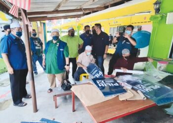 BAKRI Jamaluddin (kiri) melihat petugas menyiapkan poster di Balai Islam Bukit Rambai, Melaka. – FOTO/AMRAN MULUP