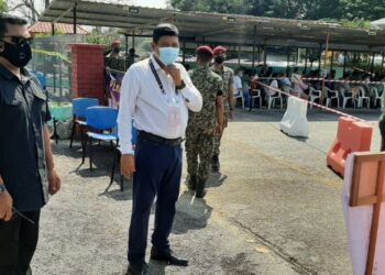 MOHAMAD Ali Mohamad (kanan) meninjau proses perjalanan pengundian awal di SK Kem Terendak 1, Sungai Udang, Melaka. - FOTO/AMRAN MULUP