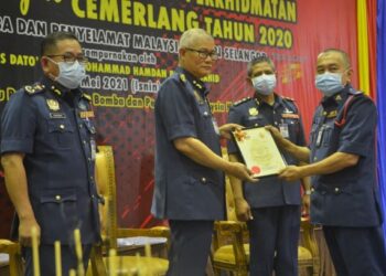MOHAMMAD Hamdan (dua dari kiri) menyampaikan sijil Anugerah Perkhidmatan Cemerlang kepada salah seorang anggota bomba dalam majlis Anugerah Perkhidmatan Cemerlang Tahun 2020 di Ibu pejabat Bomba Negeri Selangor di Shah Alam hari ini.