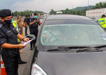 MOHD. Nadzri Hussain menyemak dokumen perjalanan sebuah kenderaan ketika mengadakan Op Rentas di lebuh raya di Kawasan Rehat dan Rawat (R&R) Seremban Arah Selatan, Lebuhraya Utara Selatan, Seremban hari ini. - FOTO/MUHAMMAD IZZAT TERMIZIE