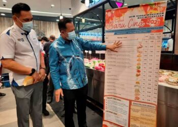 MOHD. Ridzuan Ab. Ghapar (kiri) dan Abdul Halim Hussain meninjau barangan keperluan harian sempena skim harga maksimum musim perayaan Tahun Baharu Cina 2021 di Pasar Raya AEON, Bayan Lepas, Pulau Pinang semalam.
