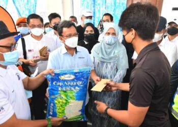 MOHD. Shafie Apdal (tiga kanan) menyampaikan sumbangan bakul makanan kepada salah seorang mangsa kebakaran di Tawau hari ini.