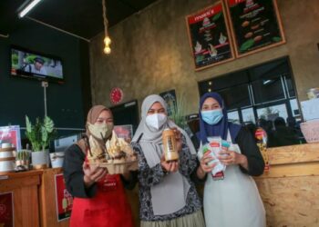 SITI Fatimah Adnan (tengah)  dan  pekerjanya menunjukkan airkrim serta  minuman gula apong jenama Mokti’s  di Kangar, Perlis,  baru-baru ini.