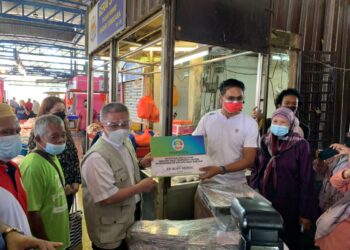 ADHAM Baba (tiga dari kiri) ketika menyampaikan bantuan kepada penerima dana pembangunan YIM di Pasar Awam Bandar Tenggara, Kota Tinggi di Johor. -UTUSAN/MASTURAH SURADI