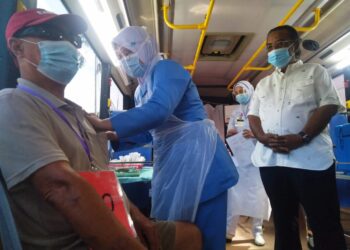 ISMAIL Othman melihat proses vaksinasi program Movak di Japerun Machap Jaya, Alor Gajah, Melaka. - UTUSAN/MUHAMMAD SHAHIZAM TAZALI