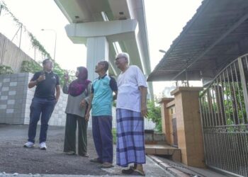 ABDUL Halin Mohd. Taharim (dua dari kanan) diiringi Muhammad Yunus Marulah melihat jejantas MRT yang dibina di hadapan kediaman mereka di Kampung Sungai Raya, Hulu Langat, Selangor, semalam. – FOTO/AMIR KHALID