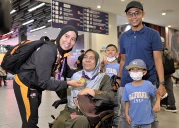 NUR Assyira Zainal Abidin (kiri) menunjukkan pingat emas yang dimenangi kepada ibunya, Hasmah Omar ketika tiba di KLIA2, Sepang kelmarin. - UTUSAN/FAIZ ALIF AHMAD ZUBIR