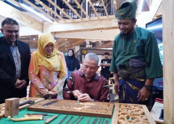 FADILAH Yusof mencuba mengukir kayu untuk perhiasan ketika melawat pameran selepas merasmikan “Wood & Lifestyle Fair” di ibu negara hari ini - Turut hadir  Timbalan Menteri Perladangan dan Komoditi, Datuk Siti Aminah Aching (dua kiri) -UTUSAN/FAUZI BAHARUDIN