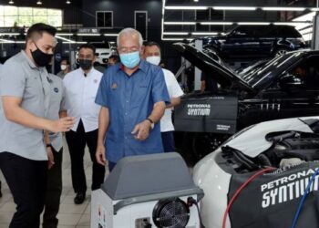 MAHDZIR Khalid (kiri) diberi penerangan oleh Mohd. Izwan Mazlan mengenai operasi pusat servis PMH oleh di Lencongan Barat, Alor Setar, hari ini. - FOTO/MOHD. RIFAAT ABD. HAMID