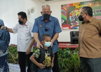 MAHDZIR Khalid menyampaikan sumbangan khas sekolah kepada pelajar dalam majlis Risda Prihatin Pekebun Kecil Makmurdi Kuala Nerang, Padang Terap, Kedah, semalam.