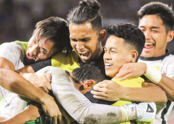 PEMAIN negara memeluk penjaga gol Harimau Malaya, Ahmad Syihan Hazmi Mohamed (kiri) yang muncul wira menyelamatkan sepakan penalti lawan ketika membantu Malaysia menyingkirkan Thailand 5-3 dalam penentuan sepakan penalti untuk mara ke final Piala Raja Thai Ke-48 di Stadium 700th Anniversary, Chiang Mai kelmarin. – IHSAN FAM