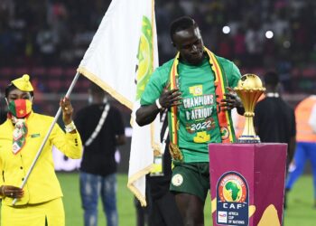 SADIO Mane melihat trofi Piala Negara-Negara Afrika yang dimenanginya  bersama Senegal kelmarin selepas menumpaskan Mesir di Stadium Olembe, Yaounde. – AFP