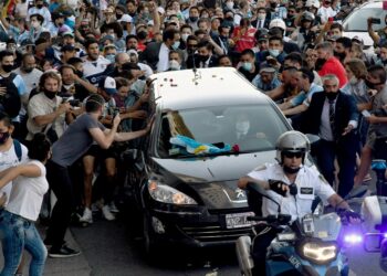 RIBUAN peminat mengiringi keranda Diego Armando Maradona yang dibawa dari istana presiden, Casa Rosada ke kawasan perkuburan di Buenos Aires hari ini. - AFP