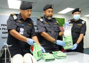 SANIFAH Yusof (tengah) bersama dua pegawai Maritim Malaysia menunjukkan bungkusan dadah dalam pelampung yang ditemukan di  perairan Tanjung Piai, Pontian, semalam. – UTUSAN/BAAZLAN IBRAHIM