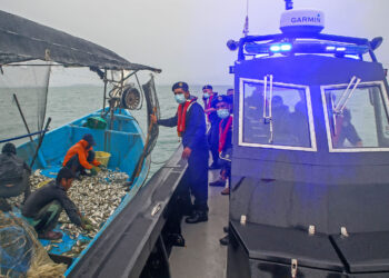 ANGGOTA Maritim Malaysia memeriksa bot nelayan semasa melakukan rondaan mencegah  penyeludupan di perairan sempadan Malaysia-Thailand semalam. - UTUSAN/SHAHIR NOORDIN