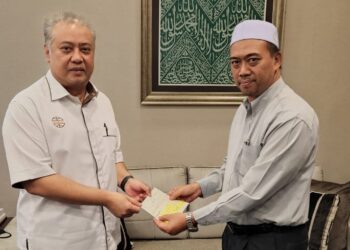 FATEH Iskandar Mohamed Mansor (kiri) menyerahkan zakat perniagaan untuk Masjid An-Nur, Saujana Utama kepada Mohd. Radzi Mohd. Zin di pejabatnya di Damansara, hari ini.