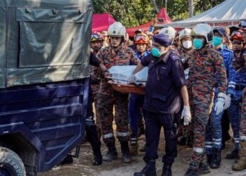 Anggota penyelamat membawa mayat kanak-kanak yang merupakan mangsa terakhir tragedi tanah runtuh yang ditemukan, petang semalam. 
– MINGGUAN/SHIIDDIEQIIN ZON