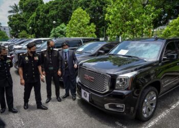 Ketua SPRM, Datuk Seri Azam Baki (dua dari kiri) bersama Ketua Pengarah Imigresen, Datuk Khairul Dzaimee Daud (tiga dari kiri) memeriksa kereta-kereta mewah yang disita daripada sindiket Pas Lawatan Kerja Sementara (PLKS) palsu selepas sidang akhbar bersama di Kuala Lumpur pada 6 April 2021.  – UTUSAN/FARIZ RUSADIO