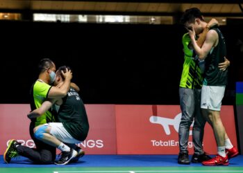 Aaron Chia- Wooi Yik  berpelukkan dengan barisan kejurulatihan selepas muncul juara dunia 2022.-IHSAN BWF