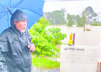 MOHAMAD Seman menunggu di tepi kawasan yang ditenggelami banjir selepas bimbang dengan keadaan tiga ekor lembunya selepas Kampung Baroh Pial dinaiki air di Rantau Panjang, Kelantan semalam. – UTUSAN/ROHANA ISMAIL